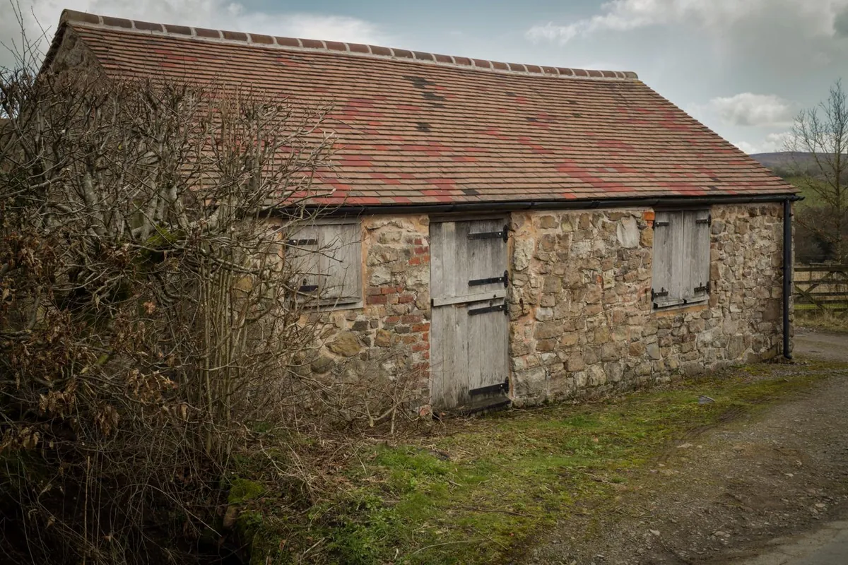 Weathered stone and brick farm barn in the countryside